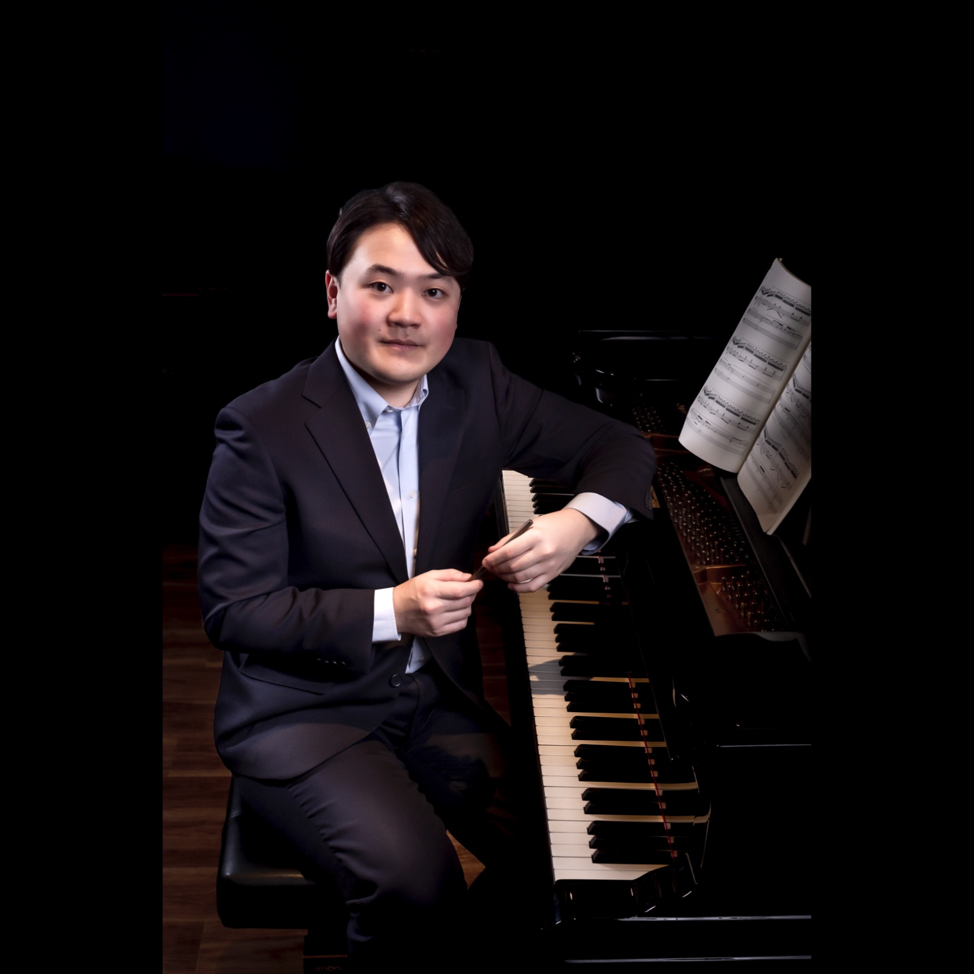 ピアノの前に座る作曲家・中村友遥